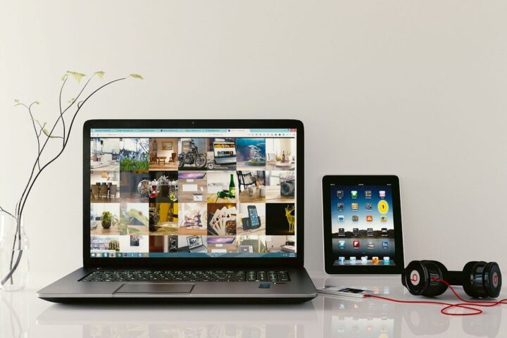 Laptop, tablet and headphones on a white desk