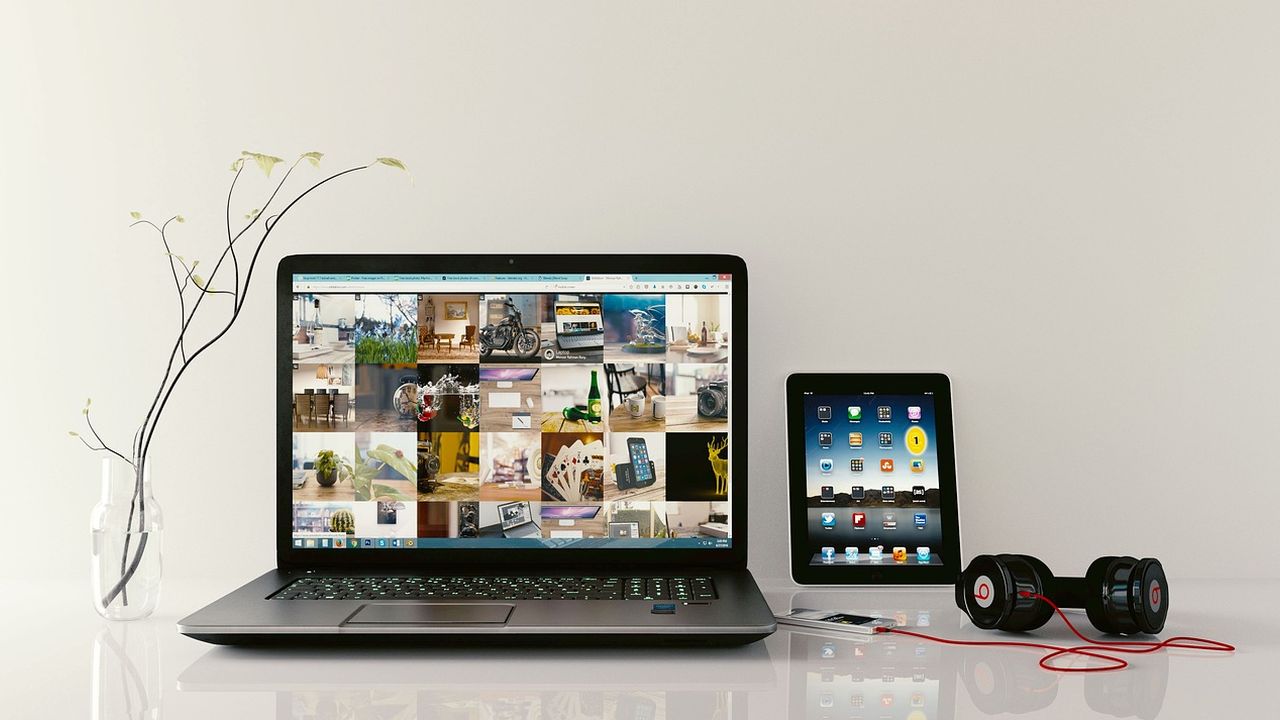 Laptop, tablet and headphones on a white desk