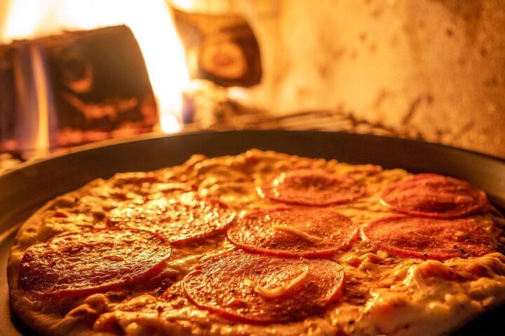 Pizza baking in a wood-fired oven