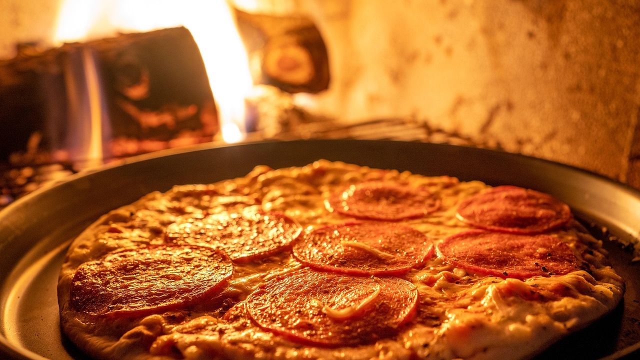 Pizza baking in a wood-fired oven
