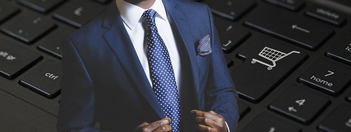 Businessman beside a keyboard with a shopping cart key