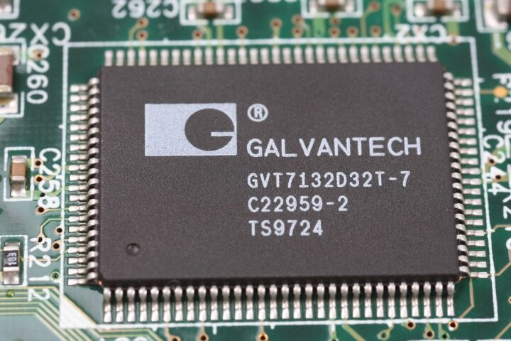 Close-up of a microchip on a green circuit board