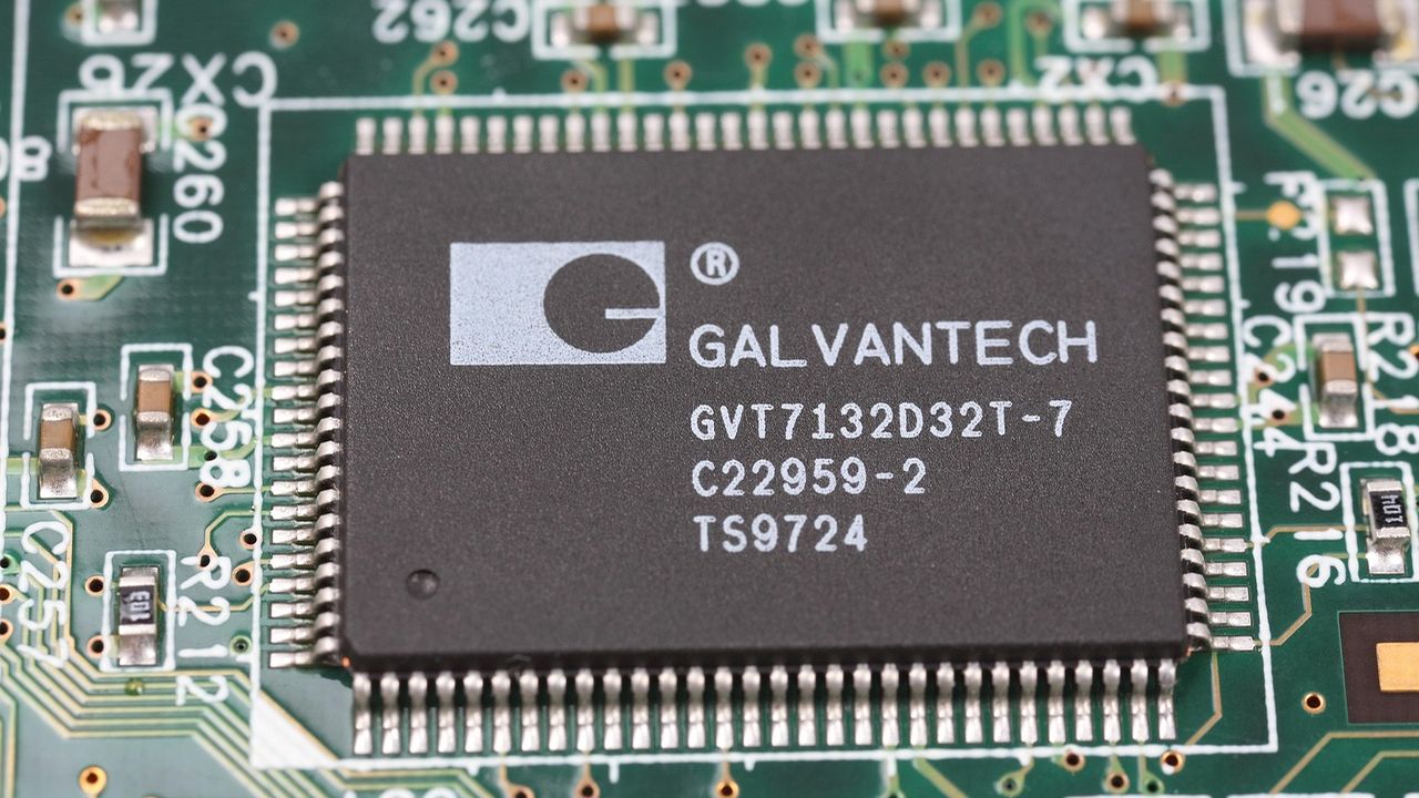 Close-up of a microchip on a green circuit board