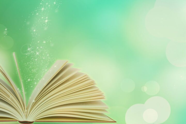 Open book with sparkles against a green background