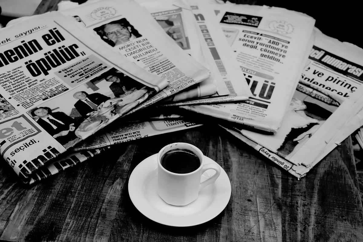 Pile of newspapers and a cup of coffee