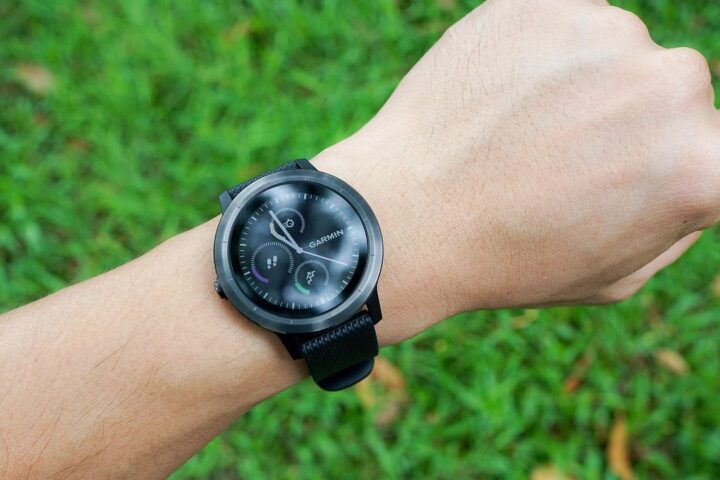 Smartwatch on a wrist over green grass