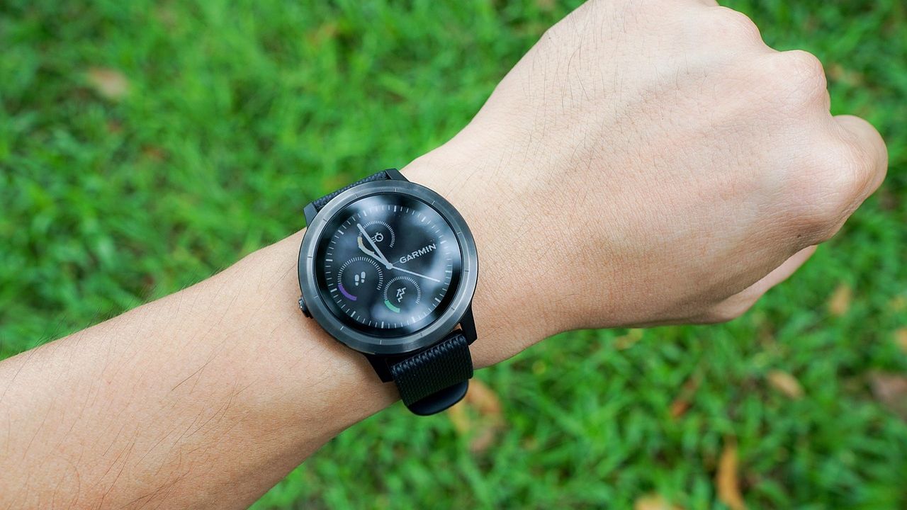 Smartwatch on a wrist over green grass