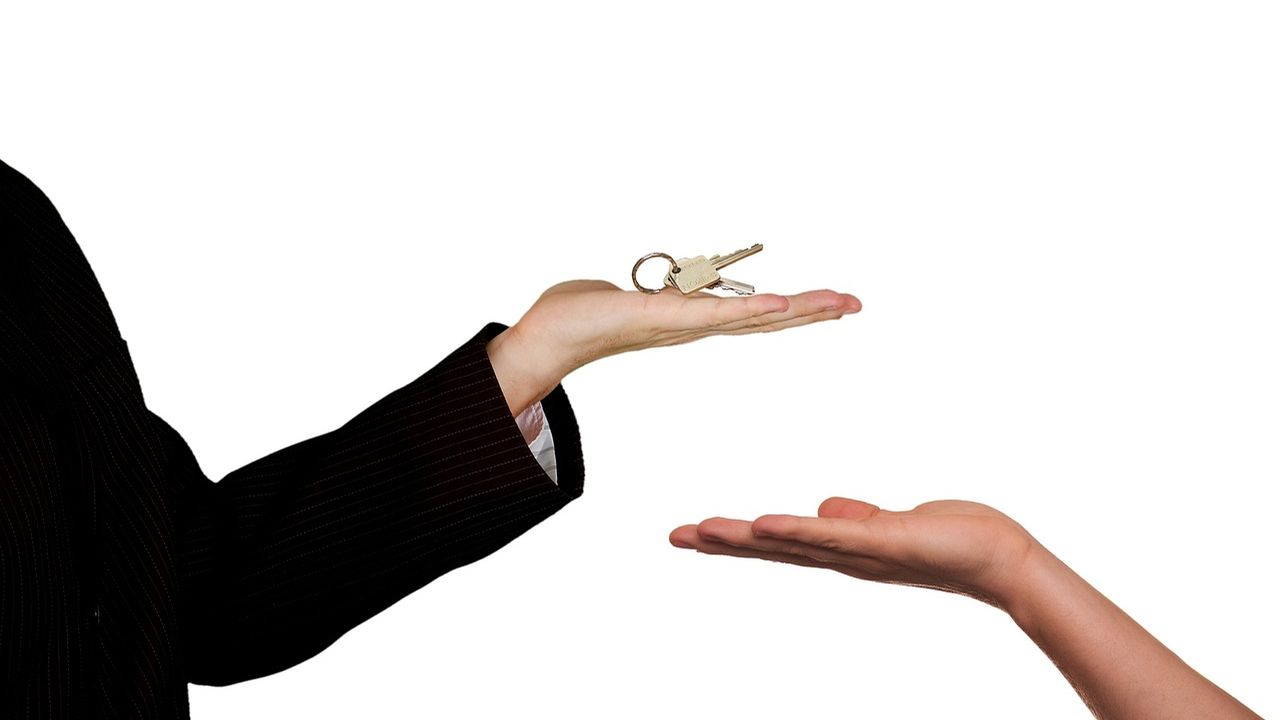 Estate agent handing house keys to a buyer