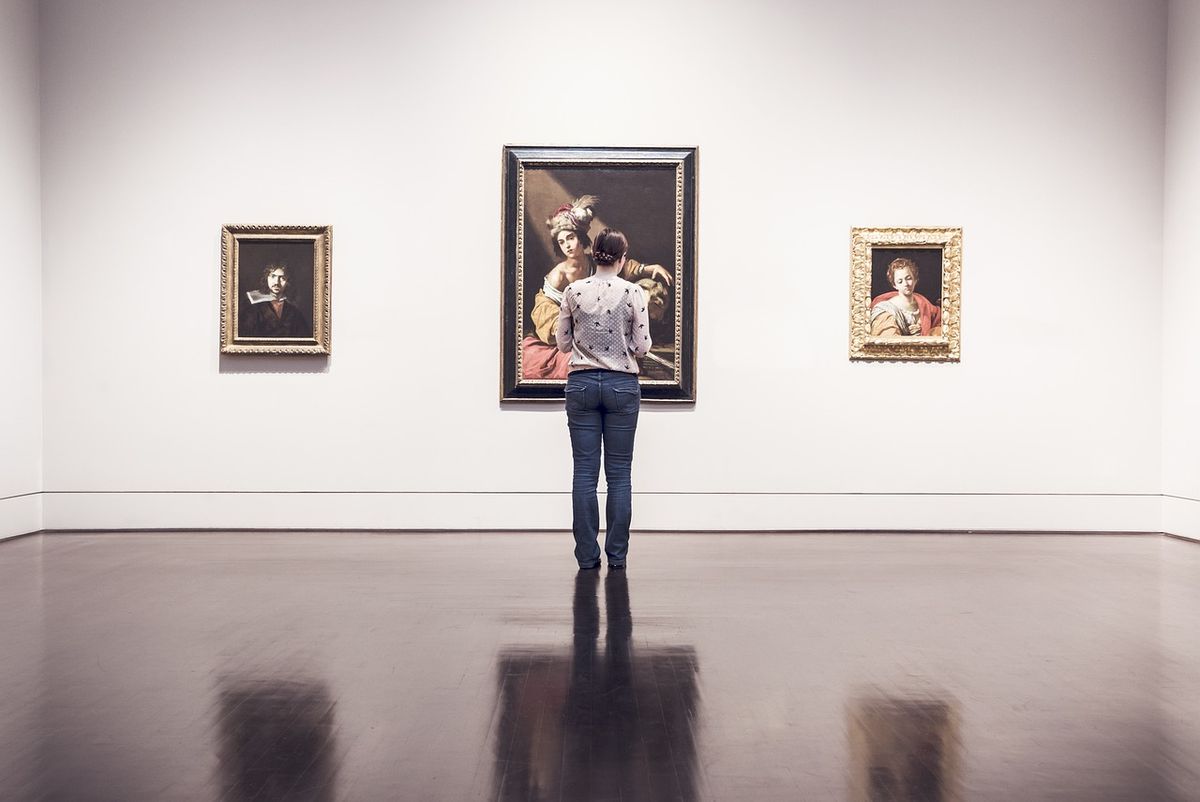 Visitor looking at a painting in a white gallery