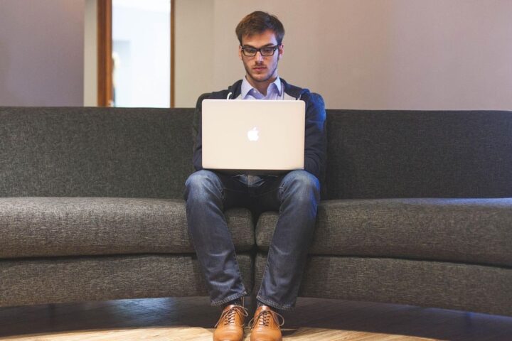 Man working on a laptop on a sofa at home
